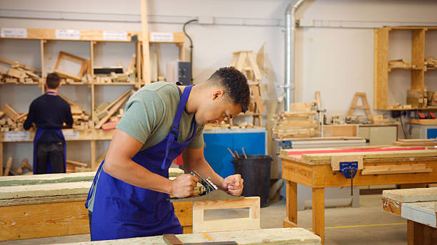 istock Male Student Studying For Carpentry Apprenticeship At College Using Wood Plane 2249306294
