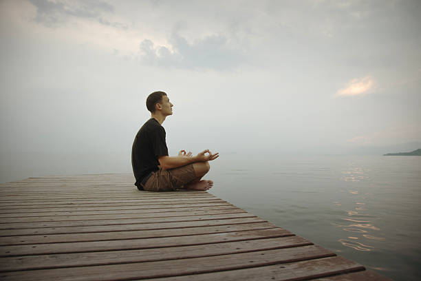 Young man meditating on a seaside pier, breathing in calm and connection