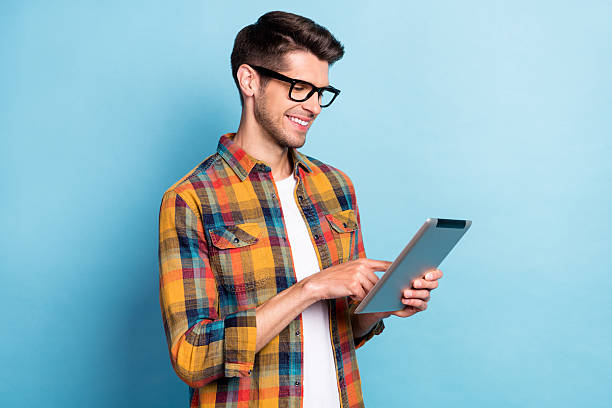 istock Portrait of attractive cheerful skilled focused guy geek using device surfing web isolated over bright blue color background 2249306519