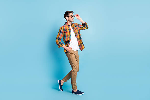 istock Photo of cute charming young guy dressed plaid shirt spectacles smiling walking looking empty space isolated blue color background 2249307219