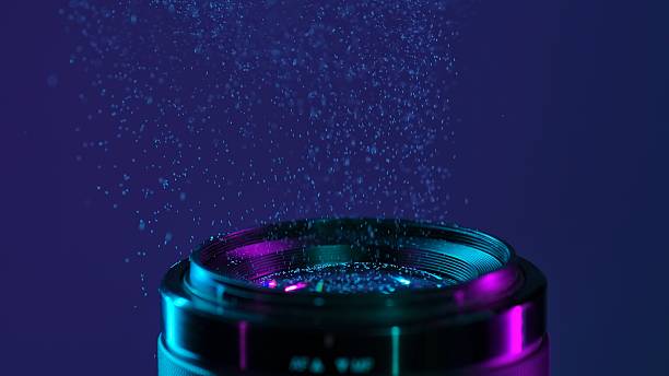 Macro shot of a camera lens with blue neon light and a cloud of fine dust creating an artistic atmosphere.
