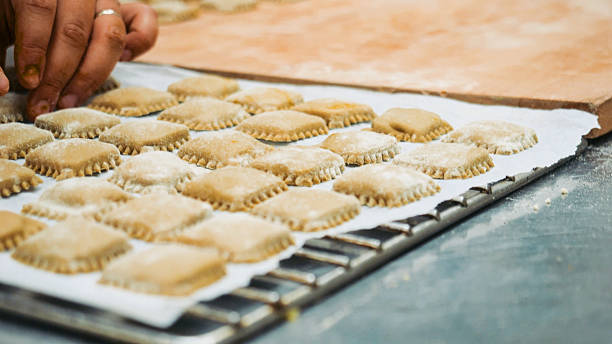 istock Chef hands carefully placing rows of freshly made square ravioli onto a baking sheet, showcasing traditional Italian culinary art and the process of preparing homemade pasta 2249308055