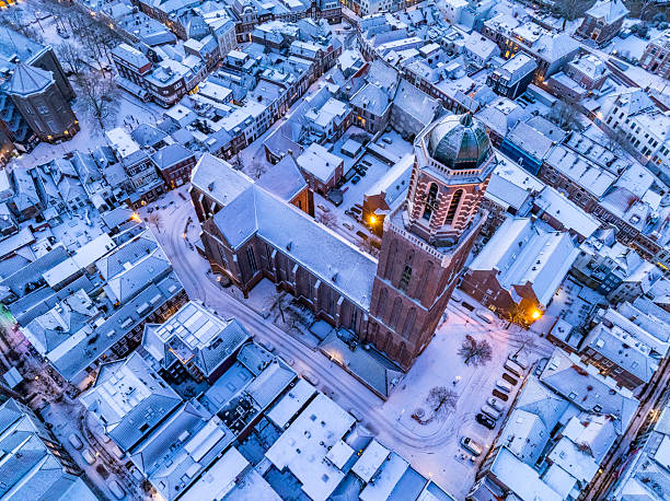 The Peperbus tower of the The Roman Catholic Onze Lieve Vrouwe ten Hemelopneming-basilica church in Zwolle rising up over the snow covered rooftops in the downtown district. The church tower, called Peperbus (pepperpot), is one of the tallest and most famous church towers in the Netherlands.