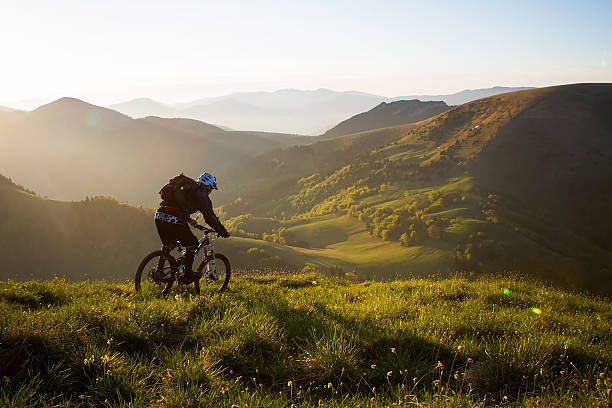 istock Young man mountain bikes down flow track at sunset 2249308881
