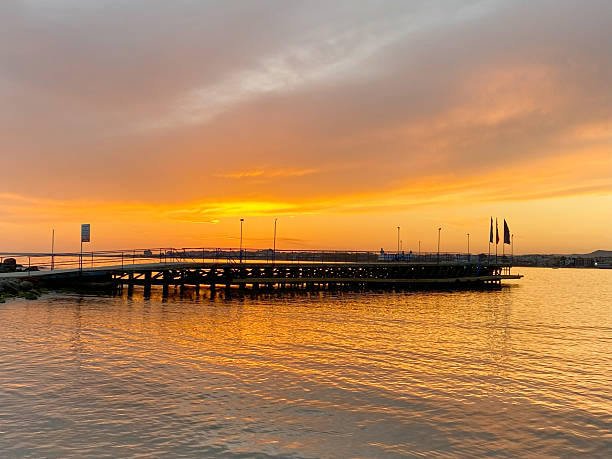 istock Sunset over calm water with a wooden pier extending into the horizon, creating a serene atmosphere and inviting reflection on nature's beauty 2249308979