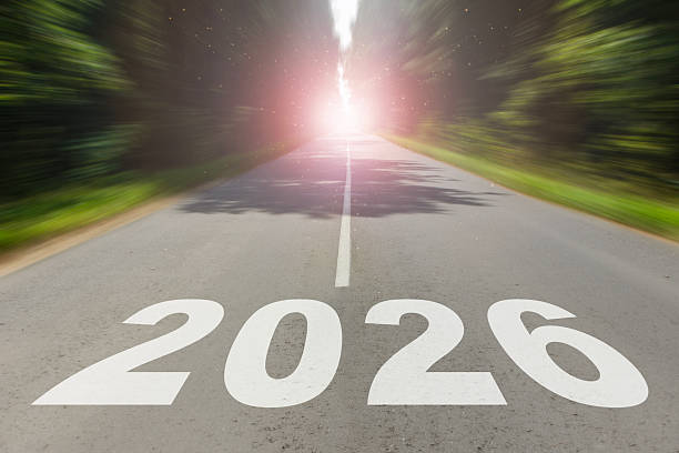 istock Straight road leading into bright sunlight with large 2026 numbers painted on asphalt. Concept of new year journey, success, and future opportunities. 2249309999