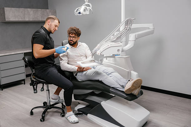 istock Dentist explaining dental health to patient using teeth model 2249310472