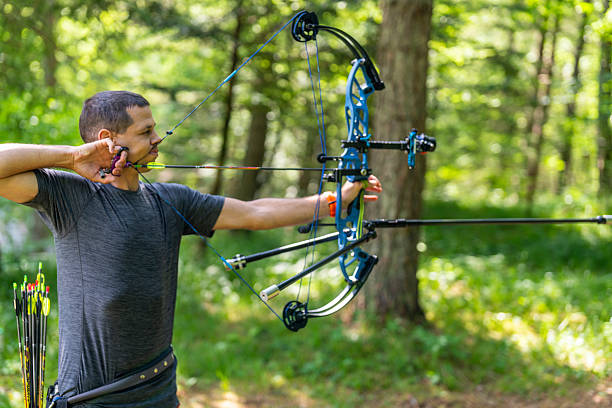 istock Focused Mid Adult Caucasian Male Archer Practicing Target Shooting in Lush Forest Setting 2249311299