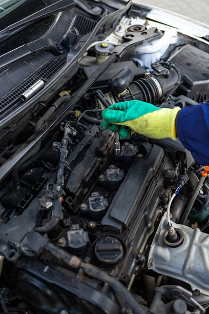 istock African mechanic using a socket wrench to tighten components on a car engine after spark plug replacement 2249312006