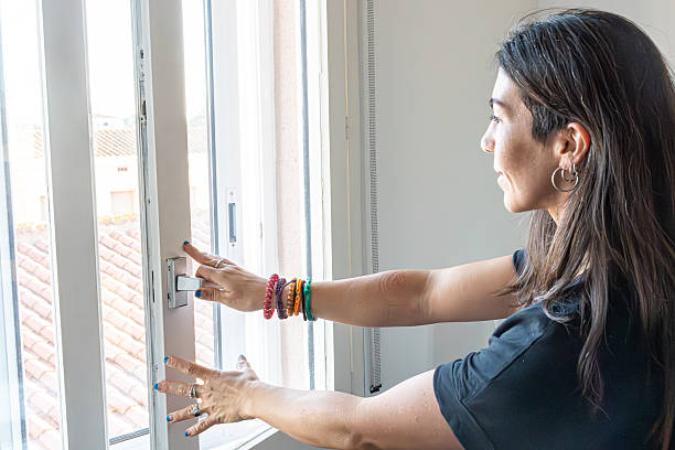 istock Woman closing white window, ensuring privacy and home security 2249312940