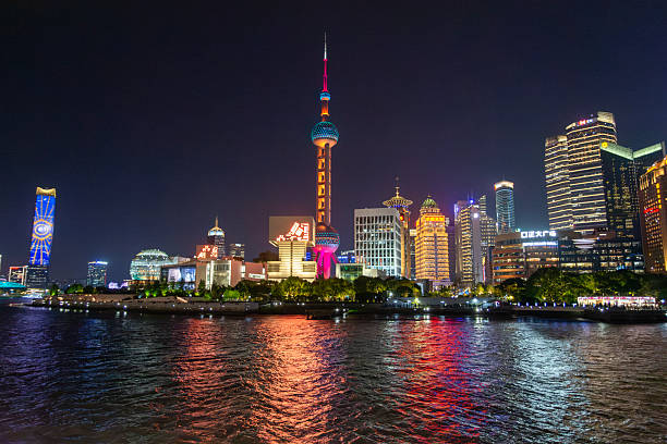 Young Chinese woman using smartphone to take photo in downtown Shanghai, China