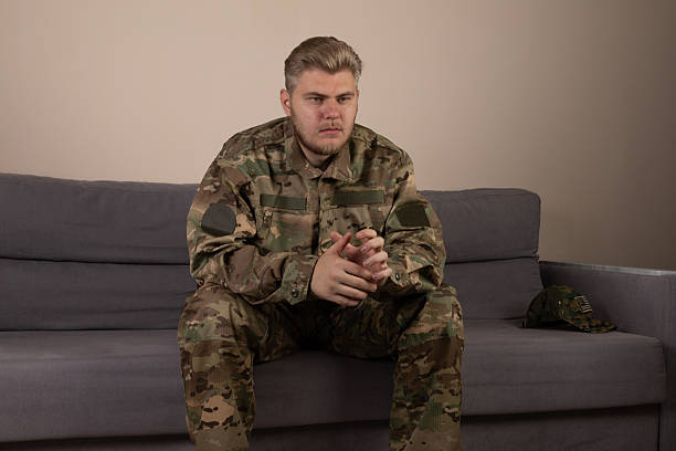 istock A soldier is sitting on a sofa, looking thoughtful 2249319723