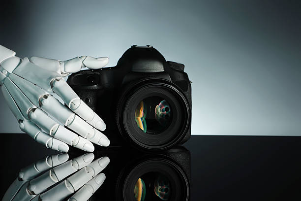 istock Artificial intelligence. Robot hand with photo camera against grey background, closeup. Space for text 2249322273