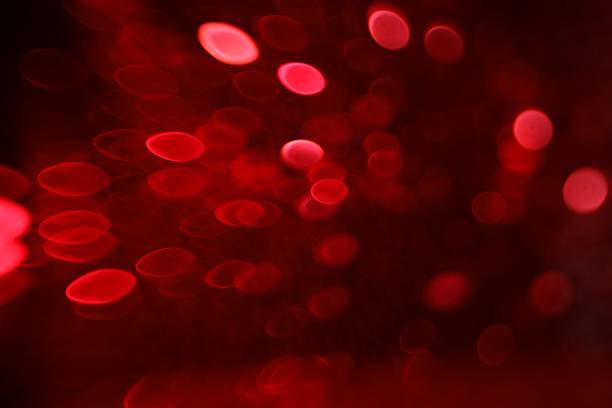 Blurred view of festive lights on red background. Bokeh effect
