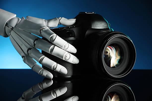 istock Artificial intelligence. Robot hand with photo camera against dark blue background, closeup 2249322337