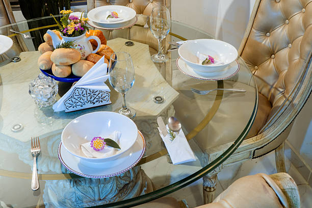 A beautifully set table adorned with plates, bowls, various utensils, and a decorative plant placed elegantly on it, creating a delightful dining atmosphere and inviting mealtime experience