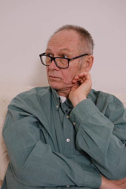 Senior man, thinking and wheelchair with memory, window and calm from nostalgia in retirement home. Relax, idea and care of person with disability at nursing facility with past and hope for future.