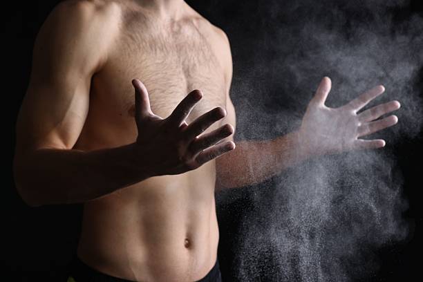 istock Man clapping hands with talcum powder before training on black background, closeup 2249328917