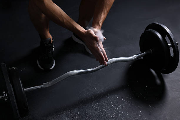 istock Man clapping hands with talcum powder before training with barbell in gym, closeup 2249328968