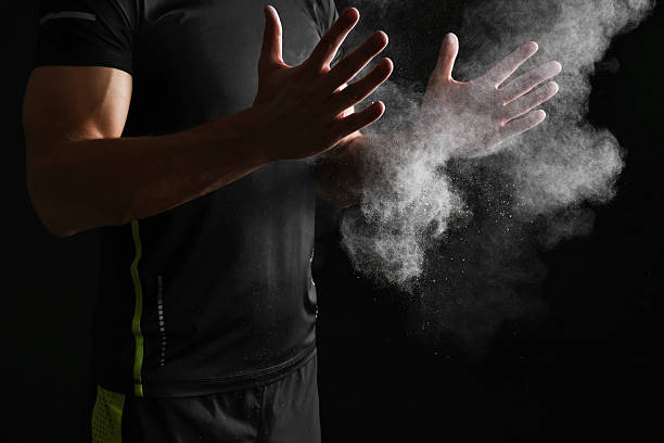 istock Man clapping hands with talcum powder before training on black background, closeup 2249328975