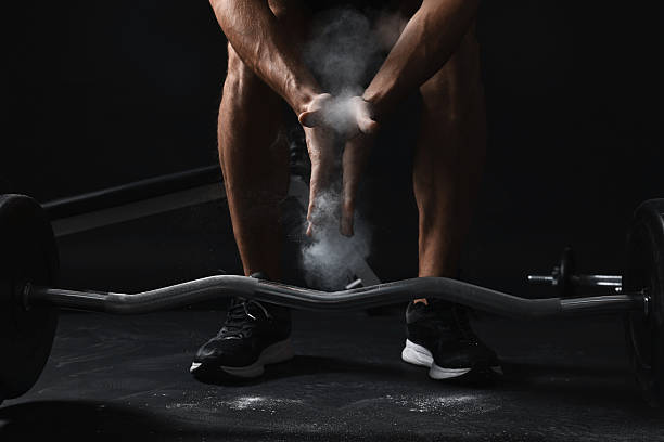 istock Man clapping hands with talcum powder before training with barbell in gym, closeup 2249329106