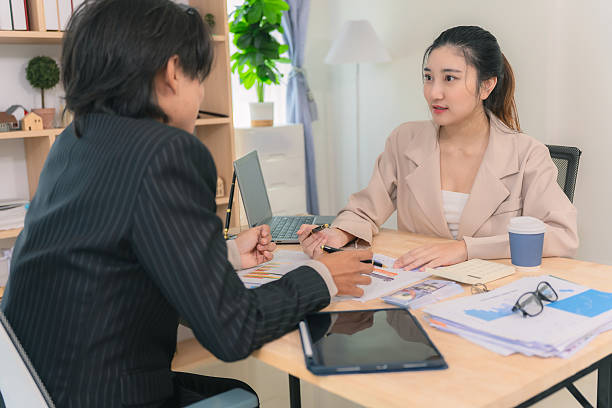 istock Asian business couple discussing finances over documents and laptop, explaining details of business growth chart. 2249330139