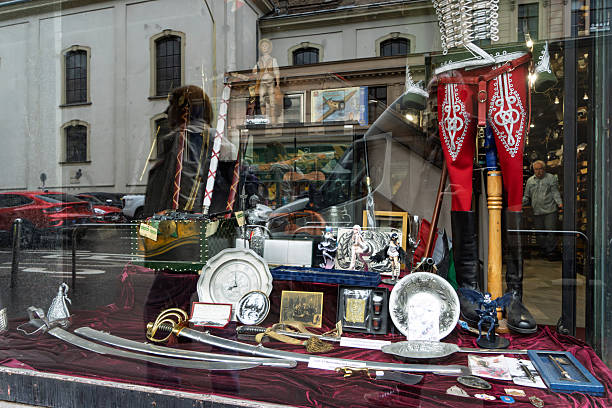 Budapest, Hungary, May 2025:An antique store window display of Hungarian memorabilia. There are Magyar flags, swords and silver plates amongst the items.