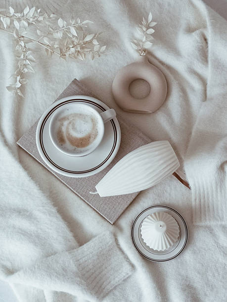 Elegant cafe shop with white stylish decorations and candles surrounding the coffee cup