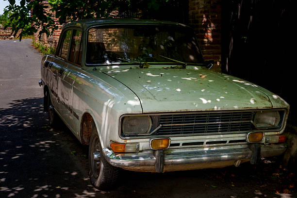 istock Abandoned Soviet sedan parked in shady alley with dappled light 2249331004