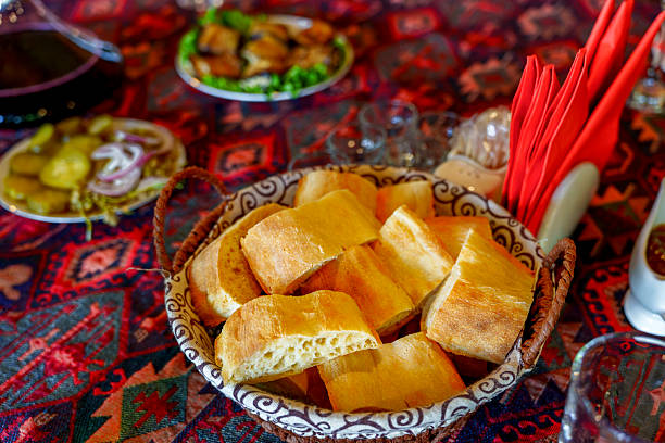istock Basket of fresh bread on colorful patterned table ready to share 2249331280