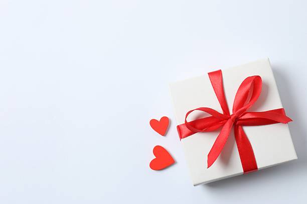 istock Festive gift with red hearts on white background 2249331763