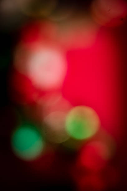 Soft, colorful bokeh lights in red, green, and gold tones creating a festive and dreamy abstract background suitable for holiday and celebration themes.
