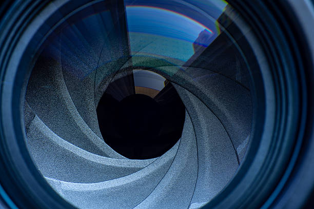 istock Macro camera lens,The diaphragm of old camera lens aperture with warm light bokeh. Selective focus with shallow depth of field. Vintage color tone filtered. Photo or video camera lens with light reflections close-up on the black background. 2249336130