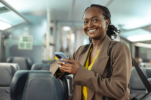 istock Young businesswoman on a train, smiling while using her phone and traveling for work 2249336501