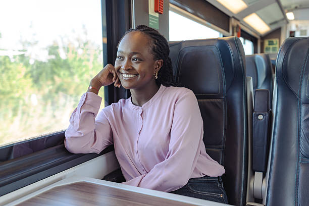 istock Smiling young woman on a train enjoying travel and work commute 2249336563