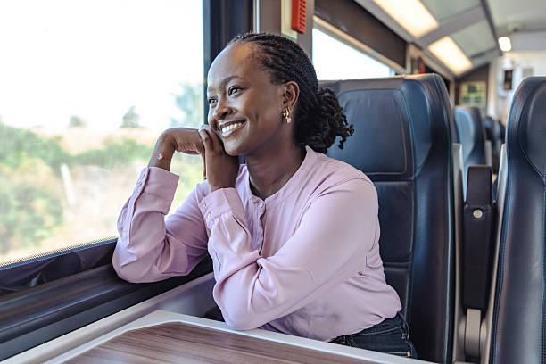 istock Young woman smiling while traveling by train, enjoying the commute and work on the go 2249336591