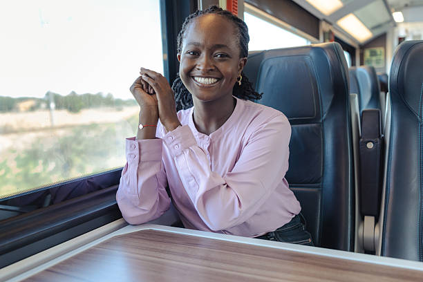 istock Young woman on a train smiling during a comfortable travel moment and work journey 2249336637