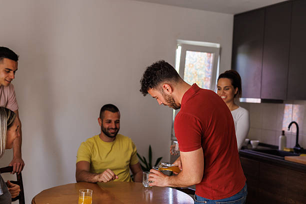 Two couples are sitting on the patio of their rented mountain cabin enjoying their friendship, playing board games and drinking beer.