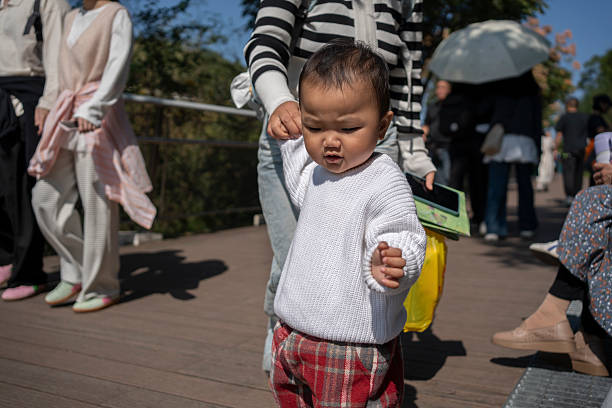 A mother holding her baby's hand during an outdoor trip