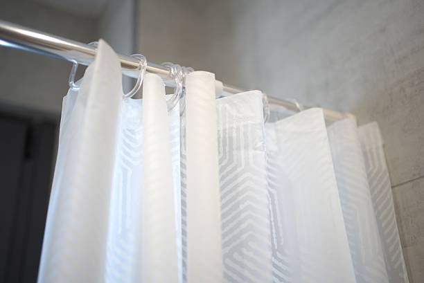 istock Shower curtain hanging in a modern bathroom with minimalist design and soft lighting 2249339864