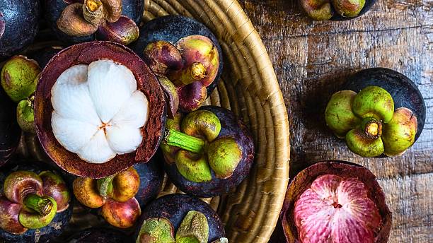 istock Freshly cut mangosteen fruit in a woven basket 2249342278