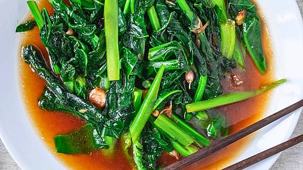 istock Steamed greens with savory sauce and chopsticks 2249342340