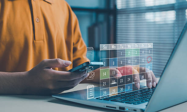 istock person uses a smartphone and laptop with a holographic digital calendar interface, representing online scheduling, task planning, productivity management, and modern digital workflow technology. 2249342578