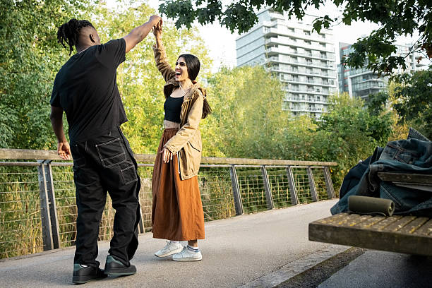 istock Two friends dancing together in city park 2249344123