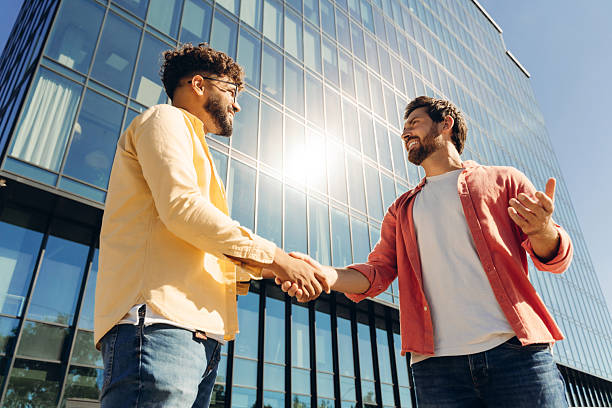 istock Two confident, successful men shaking hands after reaching an agreement during meeting near office 2249347644