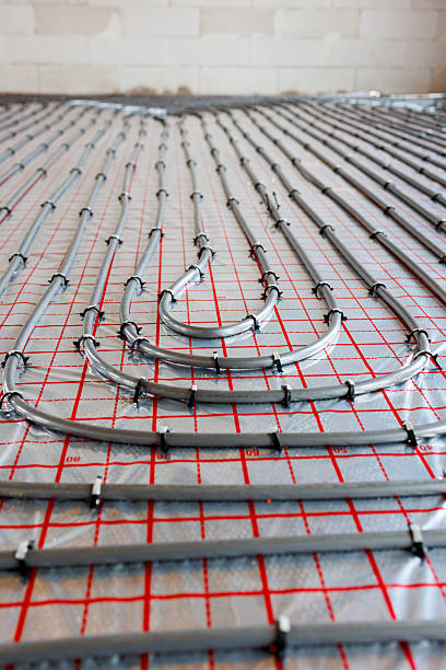 istock Radiant floor heating pipe installation in modern building 2249348176