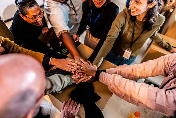 istock Volunteers celebrating with stacked hands during community action 2249348452