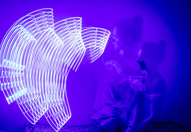 A long-exposure photograph that captures the pathway of a moving blue light source in a dimly lit room