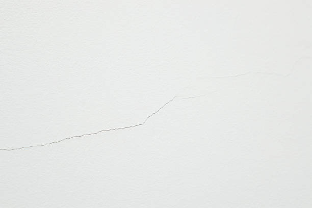 istock Shrinkage crack on a white aerated concrete wall. Fragile construction material. A Cracked Concrete Texture for a Broken Wall Concept. 2249353606