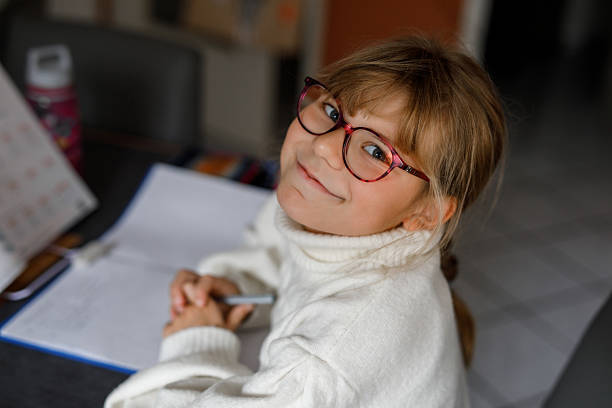 istock Little girl make school homework. Child writing in notebook and using workbook. 2249355029